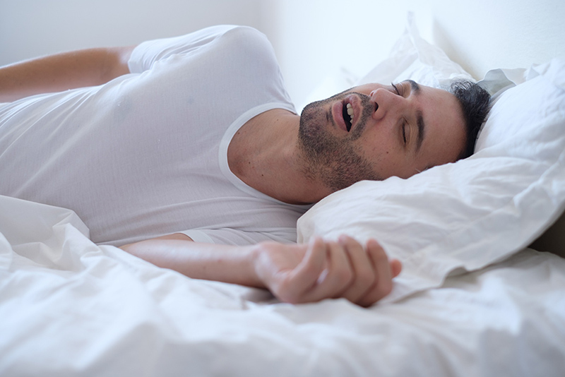 A man snoring with his mouth open while sleeping